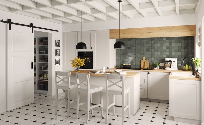  Cuisine rustique chic blanche avec îlot central, crédence carrelage en relief vert foncé, plafond à caissons blancs.